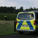 Polizeiauto steht vor einem Maisfeld