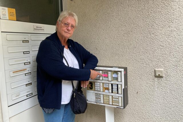 Monika Tack zeigt auf den maroden Klingelkasten des Hochhauses Pommernstraße 3 in Marl