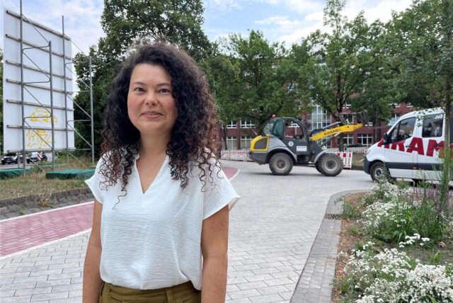 Projektleiterin Sarah Loch vom Stadtentwicklungsamt Herten am Bramhügel, im Hintergrund ein Bagger.