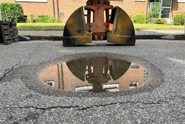 Das Loch ist Asphalt ist mit Wasser gefüllt, aber etwa fünf Zentimeter tief.