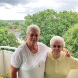 Monika Tack (l.) und Edith Lehnebach stehen auf einem Balkon.