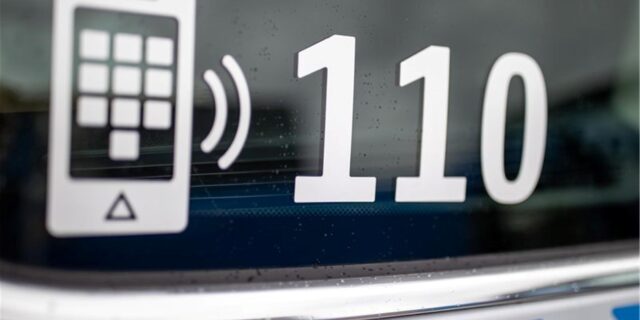 Der Nummer des Polizeinotrufs 110 steht auf der Scheibe eines Polizeifahrzeugs.