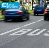 Fahrgäste stehen und sitzen in einem Linienbus.