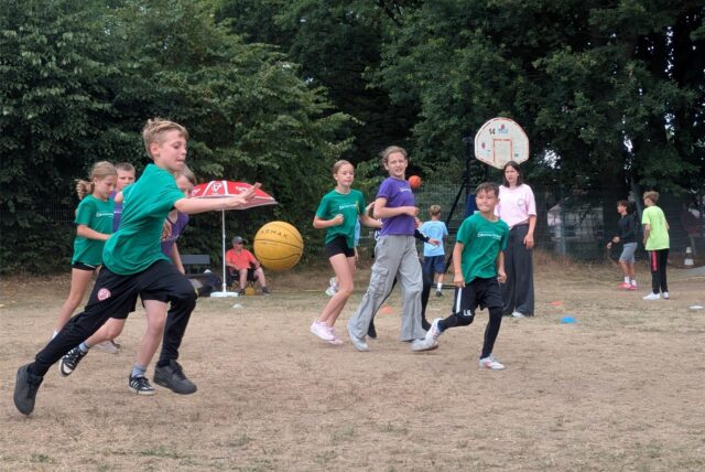 Kinder beim Ballspiel im Sand