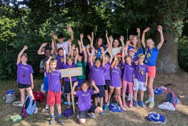 Jubelnde Kinder in einheitlichen T-Shirts einer Ländermannschaft