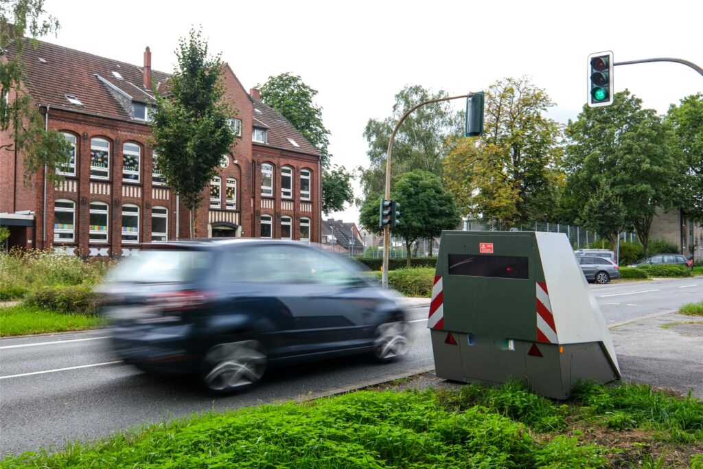 Ein Auto fährt am Panzerblitzer vorbei, der in Recklinghausen an der Henrichenburger Straße positioniert ist Ein Auto fährt am Panzerblitzer vorbei, der in Recklinghausen an der Henrichenburger Straße positioniert ist