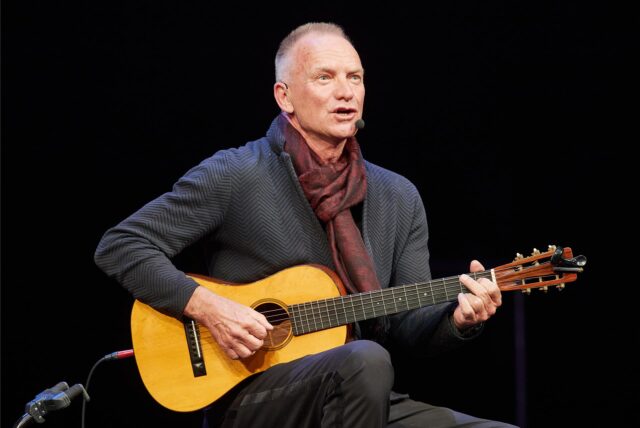 Sting, Popstar aus Großbritannien, tritt mit einer Gitarre auf der Bühne im Theater Lübeck auf. 