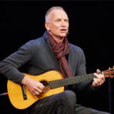 Sting, Popstar aus Großbritannien, tritt mit einer Gitarre auf der Bühne im Theater Lübeck auf. 