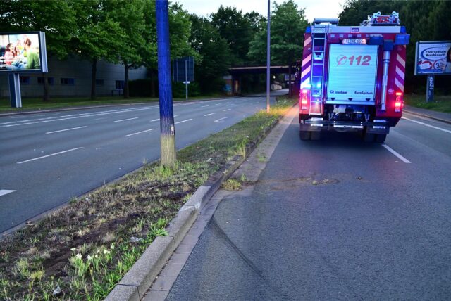 Im Bereich eines Grünstreifens zwischen zwei Fahrbahnen auf dem Dordrechtring in Recklinghausen sind Bremsspuren zu erkennen. Auf der Straße steht ein Einsatzfahrzeug der Feuerwehr.