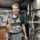 Bierbrauer Christoph Kirchhelle steht in der Brauerei des Brauhaus Rütershoff in Castrop-Rauxel. In der Hand hält er eine Probe des neuen Bieres, das beim Pferderennen am 23. August verkauft werden soll.