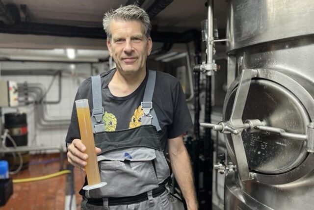 Bierbrauer Christoph Kirchhelle steht in der Brauerei des Brauhaus Rütershoff in Castrop-Rauxel. In der Hand hält er eine Probe des neuen Bieres, das beim Pferderennen am 23. August verkauft werden soll.