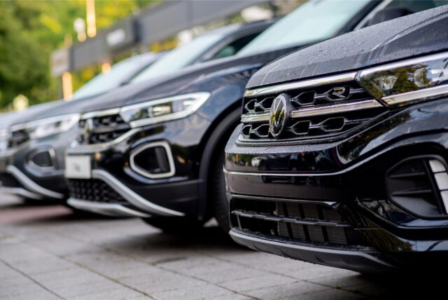 Neuwagen der Marke Volkswagen stehen vor einem Autohaus.