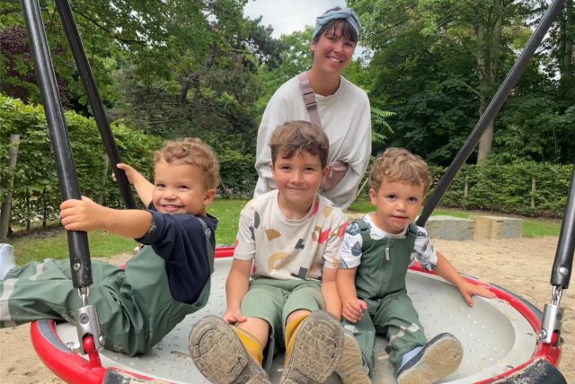Die Kinder der Familie Berger sitze auf einer Schaukel, Mutter Anna steht dahinter.