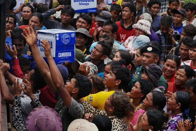 Kambodschaner drängen sich in der Batthkoa-Grundschule in der Provinz Oddar Meanchey, Kambodscha, um Trinkwasser zu erhalten, das von einem lokalen Unternehmen namens Cambodia gespendet wurde. Die Kämpfe an der Grenze zwischen Thailand und Kambodscha gehen in den dritten Tag.